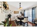 Dining room featuring a dark wood table, seating for six, a decorative mirror, and natural light at 2919 Foraker Way, Kissimmee, FL 34758