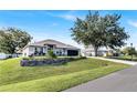 Well-maintained single-story home with a landscaped front yard, a driveway, and mature shade trees at 2919 Foraker Way, Kissimmee, FL 34758