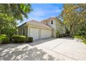 Side view of the house showcasing a three-car garage and spacious concrete driveway at 307 Running Wind Ln, Maitland, FL 32751