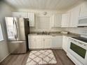 Bright kitchen featuring white cabinets, modern appliances, and a window over the sink at 31538 Anderson Dr, Tavares, FL 32778
