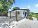Spacious carport with wooden support beams and a freshly painted driveway at 3321 Mahalia Pl, Orlando, FL 32805