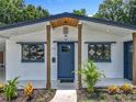 Charming home featuring a blue front door, decorative windows, and modern landscaping at 3321 Mahalia Pl, Orlando, FL 32805