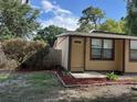 Inviting home entrance featuring a well-manicured lawn and flowerbeds at 34 W Bob White St, Apopka, FL 32712