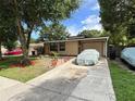 Lovely home with mature landscaping and a covered vehicle in the driveway at 34 W Bob White St, Apopka, FL 32712