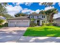 Beautiful gray home with a three-car garage, lush landscaping, and a vibrant green lawn at 394 Baymoor Way, Lake Mary, FL 32746