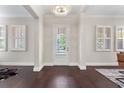 Elegant foyer showcasing dark wood floors, white trim, plantation shutters, and a modern chandelier at 4310 Ethan Lane Ln, Orlando, FL 32814