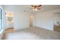 Bright primary bedroom featuring neutral carpet, a ceiling fan, an ensuite and a large closet at 4800 Reginald Rd, Orlando, FL 32829