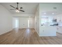 Bright living room featuring wood floors, neutral paint, a ceiling fan and views to the kitchen at 4800 Reginald Rd, Orlando, FL 32829