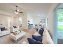 Bright, open living room features light hardwood floors, modern ceiling fan, and neutral decor at 4800 Reginald Rd, Orlando, FL 32829