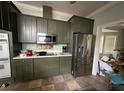 Functional kitchen with stainless steel appliances and olive green cabinets, ready for customization at 6230 Cranberry Dr, Port Orange, FL 32127