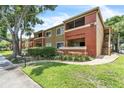 Condominium building featuring well-manicured lawns, mature trees, and inviting outdoor spaces at 664 Kenwick Cir # 104, Casselberry, FL 32707