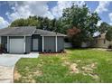 Cozy single-story home featuring a lovely front yard, a garage, and an inviting entrance at 7266 Oak Meadows Cir, Orlando, FL 32835