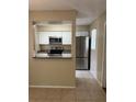 Charming kitchen featuring stainless steel appliances, granite countertops, and white cabinets at 7266 Oak Meadows Cir, Orlando, FL 32835