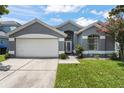Lovely single-story home featuring a well-maintained lawn, two-car garage, and manicured landscaping at 10064 River Glen Ct, Orlando, FL 32825