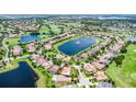 An aerial view of a community surrounded by a golf course, ponds, lakes, and lush landscaping at 10630 Mobberley Cir, Orlando, FL 32832