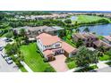 Stunning aerial view of the home with a red tile roof and lush landscaping, near a pond and golf course at 10630 Mobberley Cir, Orlando, FL 32832
