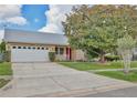Well-maintained single-story home boasts a two-car garage, manicured lawn, and a freshly painted exterior at 14063 Ithaca Way, Orlando, FL 32826