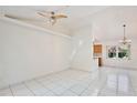 Bright and airy living room features tiled floors, high ceilings, and a view of the kitchen and dining area at 14063 Ithaca Way, Orlando, FL 32826