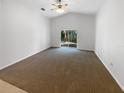 Spacious living room showcasing vaulted ceilings, plush carpeting, and sliding glass door at 142 E 9Th St, Chuluota, FL 32766