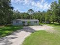 Charming single-story home with black shutters, a covered front porch, and a gravel driveway at 18166 Lynbrook Rd, Orlando, FL 32820