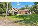 Charming one-story home featuring lush landscaping and a well-manicured lawn and a beautifully maintained facade at 21795 Sw 88Th Lane Rd, Dunnellon, FL 34431