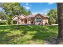 Charming one-story home featuring lush landscaping and a well-manicured lawn and a beautifully maintained facade at 21795 Sw 88Th Lane Rd, Dunnellon, FL 34431