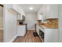 Classic kitchen featuring white cabinets, granite countertops, and modern appliances at 220 Colony Pl, Casselberry, FL 32707