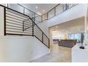 Bright foyer with an open staircase, modern railings, and views to the living room and open-concept kitchen at 2537 Shanti Dr, Kissimmee, FL 34746