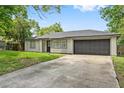 Single-story home with a long driveway leading to an attached garage at 2753 Beckwith St, Deltona, FL 32738