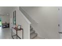 Neutral hallway featuring tile floors, staircase, and natural light at 3304 Wye Oak Dr, Apopka, FL 32703