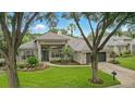 Inviting single-Gathering home featuring a tile roof, lush landscaping, and an attached two car garage at 387 Devon Pl, Lake Mary, FL 32746