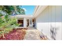 Inviting front entrance with a glass paneled door, surrounded by mulch landscaping and vibrant green plants at 42 W Grenewood Ln, Haines City, FL 33844