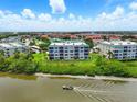 Wide angle aerial shot of condo building on the water with a boat passing by at 426 Bouchelle Dr # 202, New Smyrna Beach, FL 32169
