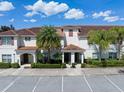 Beautiful townhome boasts a tile roof, neatly trimmed landscaping, and ample parking for residents and guests at 4895 Clock Tower Dr, Kissimmee, FL 34746