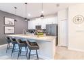 Modern kitchen with island, quartz countertops, stainless steel appliances, and stylish pendant lighting at 5025 Windermere Ave, Kissimmee, FL 34746