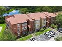 A well-kept condo building showcasing its red tile roof, neat landscaping, and convenient parking at 5160 Conroy Rd # 21, Orlando, FL 32811