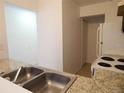 Efficient kitchen with stainless steel sink, granite countertops, and standard appliances at 5220 Via Hacienda # 212, Orlando, FL 32839