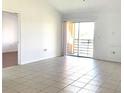 Bright, open living space with tile flooring and a sliding glass door to the balcony at 5220 Via Hacienda # 212, Orlando, FL 32839