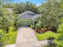 Charming green home featuring a lush landscaped yard, large driveway, and a well-manicured lawn at 5263 Beach River Road, Windermere, FL 34786