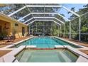 Screened pool with attached spa, surrounded by a spacious deck, offering a private outdoor oasis at 6092 Sabal Hammock Cir, Port Orange, FL 32128