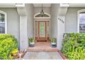 The inviting front entrance features a glass door, sidelights, and decorative plants, adding to the curb appeal at 6630 Hidden Beach Cir, Orlando, FL 32819