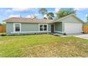 Charming single-story home with a well-kept lawn and convenient two-car garage at 705 Ibis Ave, Deltona, FL 32738
