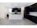 Modern kitchen featuring dark cabinetry, a large center island, and stainless steel appliances at 7530 Summerlake Groves St, Winter Garden, FL 34787