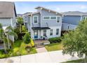 Modern two-story home with a blue front door, manicured lawn, and inviting front porch area at 8290 Nemours Pkwy, Orlando, FL 32827