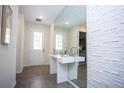Bright entryway with tile floors, modern console table, statement mirror, and textured accent wall at 9071 Sunshine Ridge Loop, Kissimmee, FL 34747