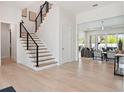 Inviting foyer with hardwood floors, modern staircase, and an open view to the living room at 9156 Sheen Sound St, Orlando, FL 32836