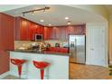 Eat-in kitchen boasting dark wood cabinets, stainless steel appliances, and barstool seating at 101 S Eola Dr # 1021, Orlando, FL 32801