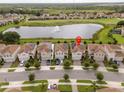 An aerial view of a neighborhood with houses, a lake and a golf course at 1097 Trappers Trail Loop, Davenport, FL 33896