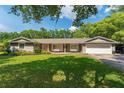 Lovely single-story house showcasing a well-kept lawn, mature trees, and a two car garage at 1111 Pinar Dr, Orlando, FL 32825