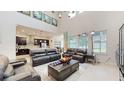 Open-concept living room with dark-stained kitchen cabinetry, a dining nook, and leather furniture at 14124 Dove Hollow Dr, Orlando, FL 32824